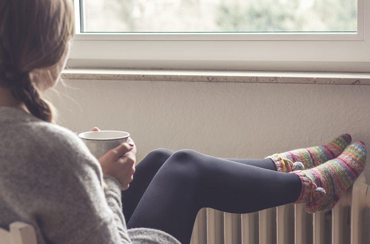 Femme mettant ses pieds sur un radiateur