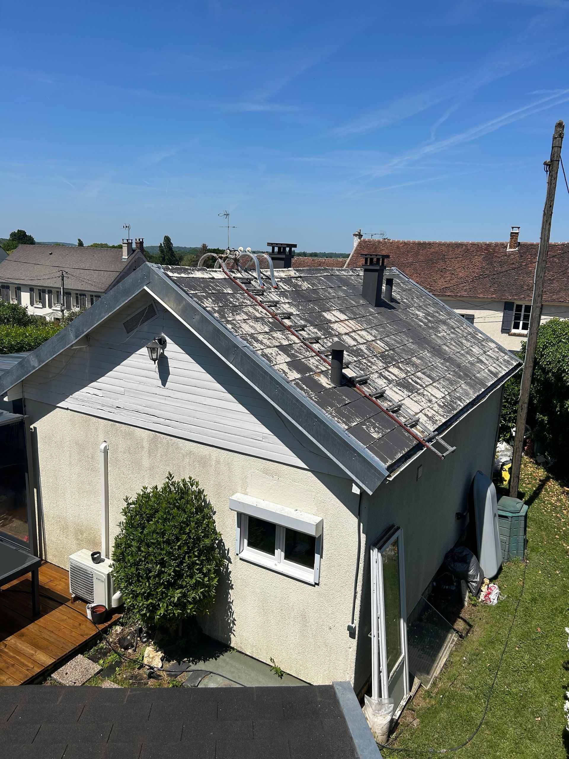 Échelles placées sur les deux pans d'un toit en vue de son nettoyage