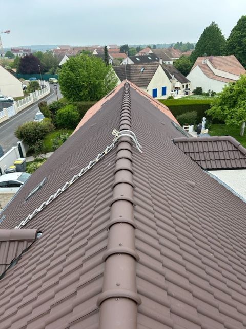 Échelle de toit placée sur une toiture en tuiles