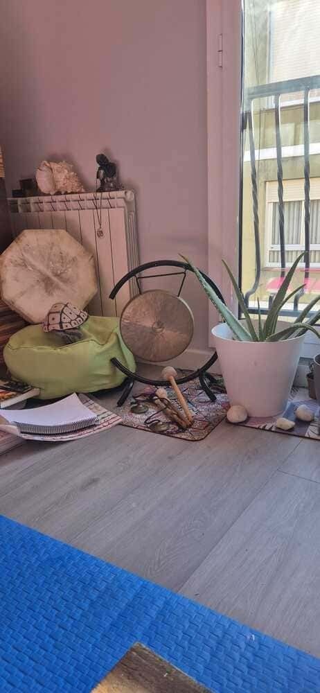 Una planta en maceta está sobre una mesa al lado de una ventana.