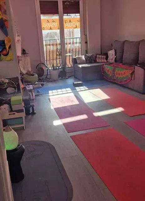 Una sala de estar con sofá, alfombra y balcón.