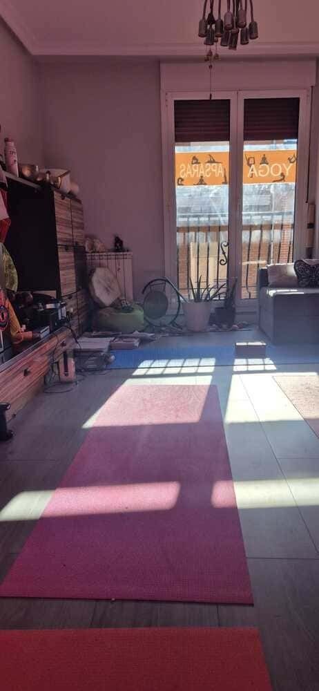 Una sala de estar con alfombra en el suelo y un balcón.