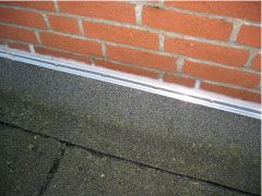 Eine Nahaufnahme einer Backsteinmauer mit einem Dach davor.