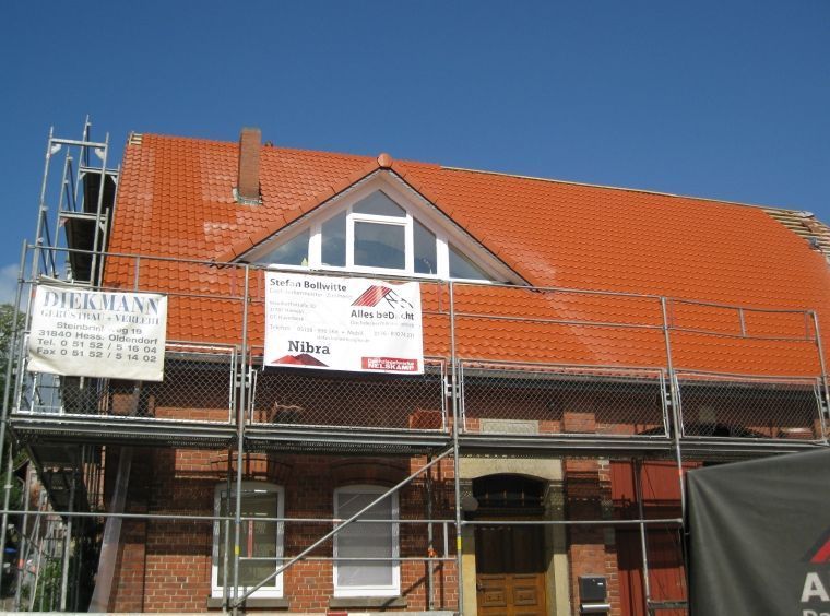 Ein Backsteingebäude mit Gerüst und einem Schild