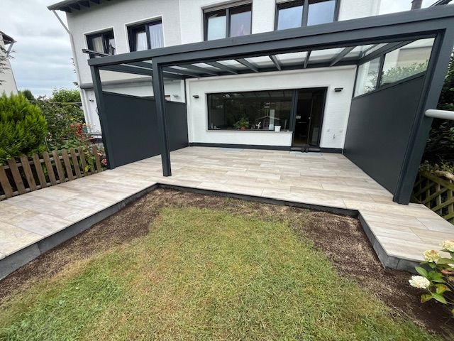 Eine Terrasse mit Pergola und Zaun vor einem Haus. Foto von Dennis Schoo Gartenideen & Gestaltung