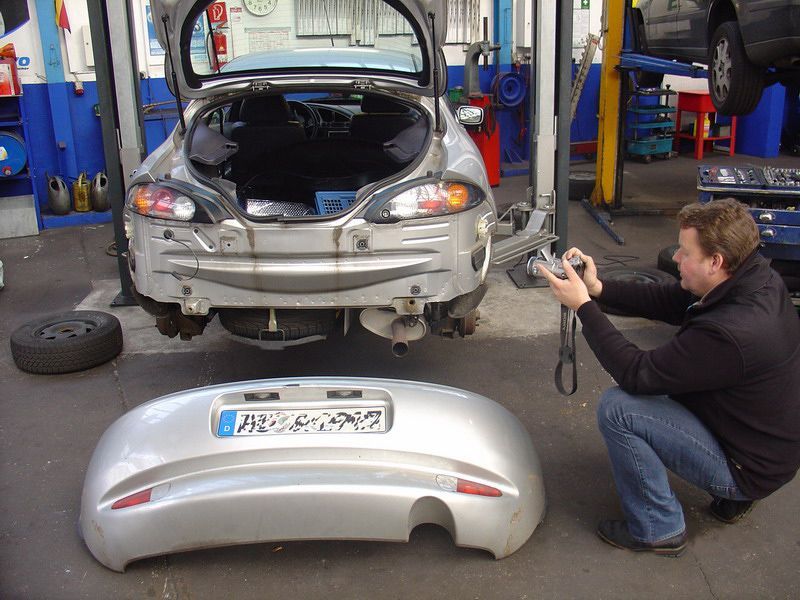 Ein Mann macht ein Foto von einem silbernen Auto mit dem Kennzeichen sn - a - np - 2