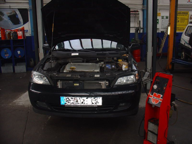 Ein schwarzes Auto mit geöffneter Motorhaube und einem Nummernschild mit der Aufschrift „SNK“