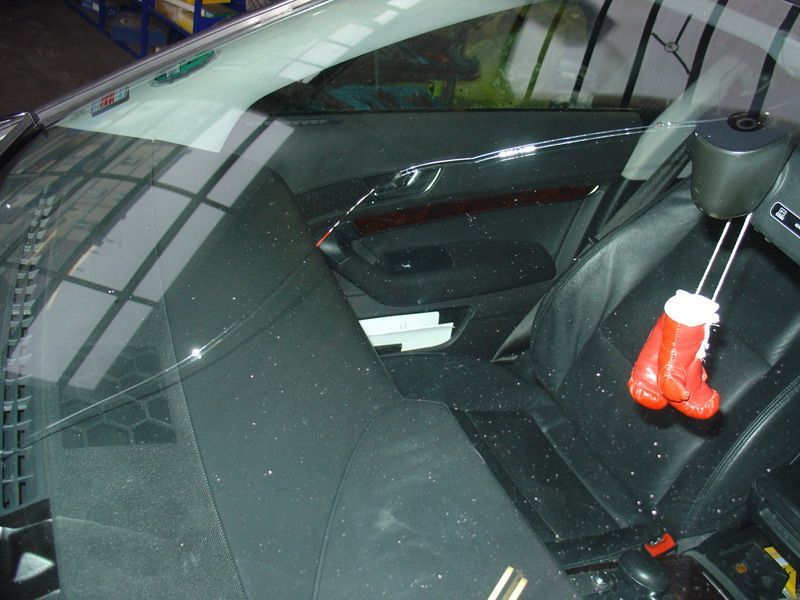 Ein Paar rote Boxhandschuhe hängen an der Windschutzscheibe eines Autos