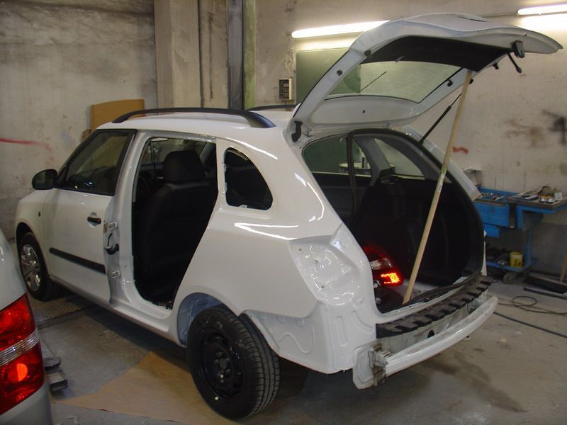 Ein weißes Auto mit offenem Kofferraum in einer Garage