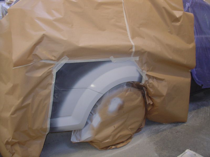 Ein weißes Auto ist mit braunem Papier bedeckt