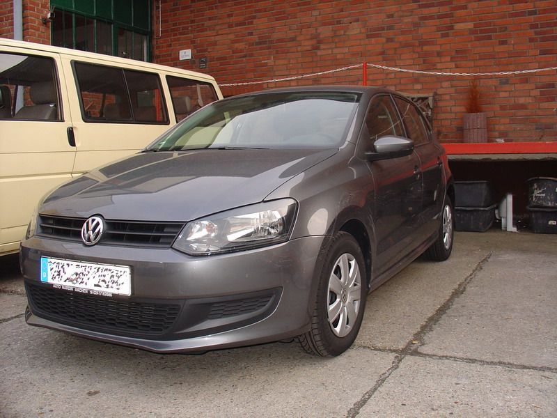 Ein Volkswagen Polo steht vor einem Backsteingebäude