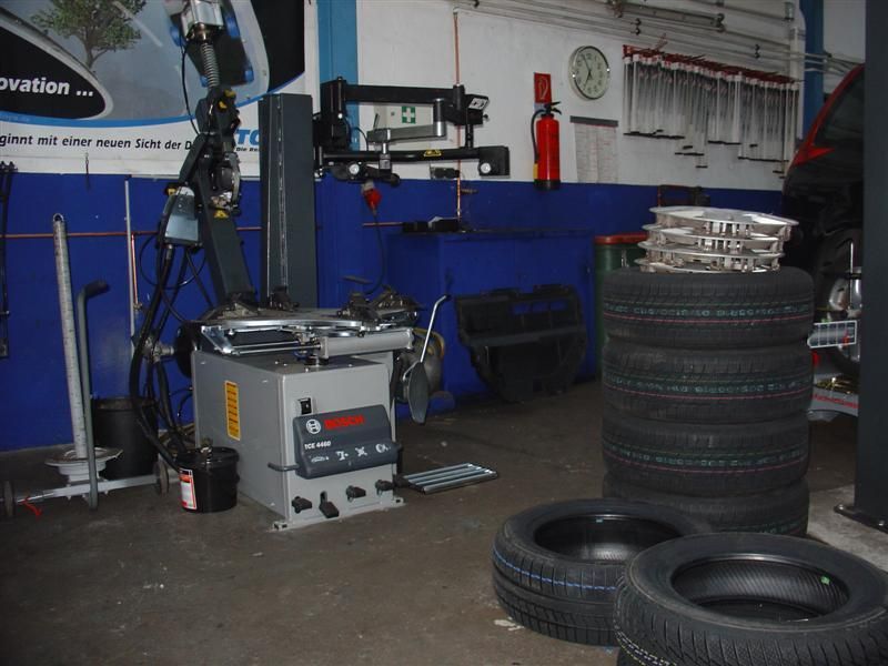 Ein Stapel Reifen steht vor einer Maschine mit der Aufschrift „Bosch“