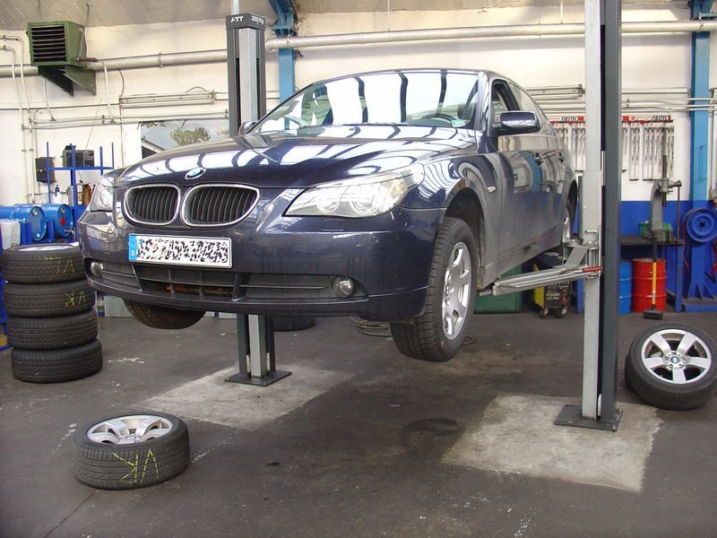 Ein bmw steht auf einer hebebühne mit einem nummernschild mit der aufschrift jc 973 tnk