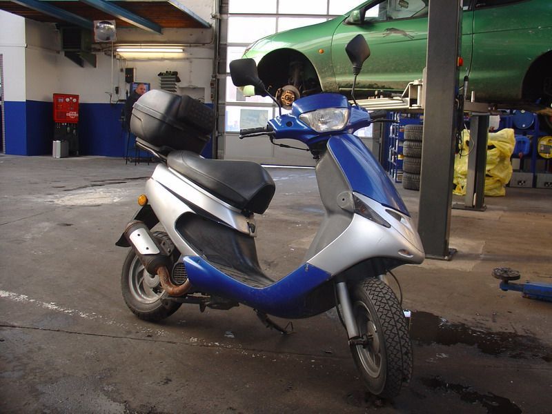 Ein blau-silberner Roller steht in einer Garage