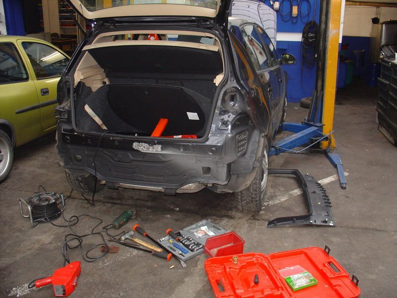 In einer Garage wird an einem schwarzen Auto gearbeitet