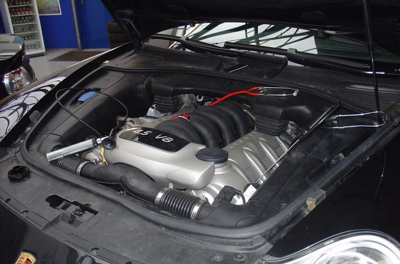 Die Motorhaube eines schwarzen Porsche ist offen