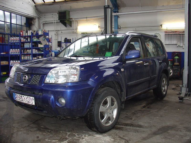 Ein blauer Nissan SUV steht in einer Garage