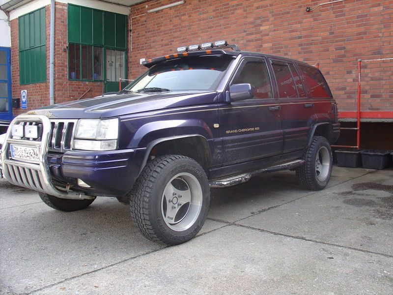 Ein blauer Jeep steht vor einem Backsteingebäude