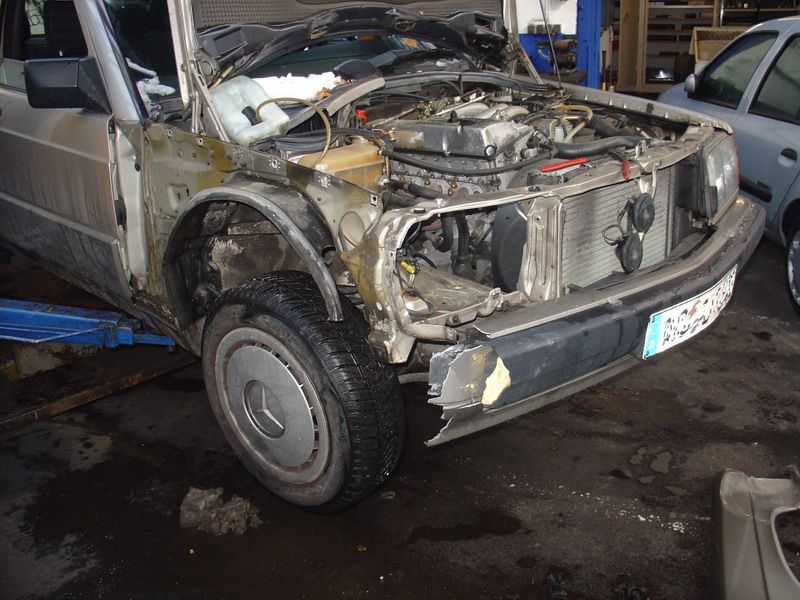 Ein Mercedes mit offener Motorhaube sitzt auf einer Hebebühne