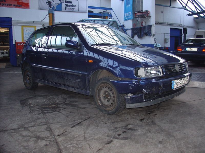 Ein blaues Auto steht in einer Garage mit einem Schild mit der Aufschrift