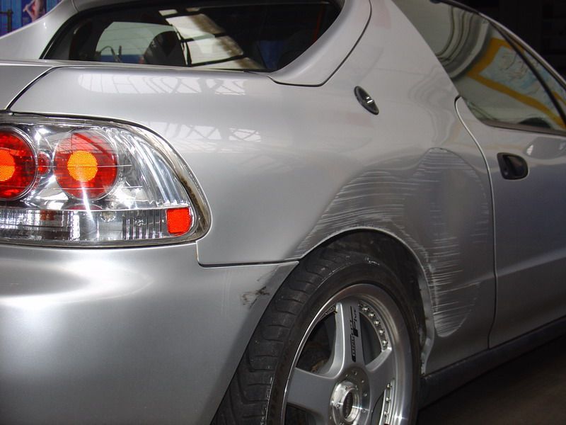 Ein silbernes Auto mit rotem Rücklicht steht in einer Garage