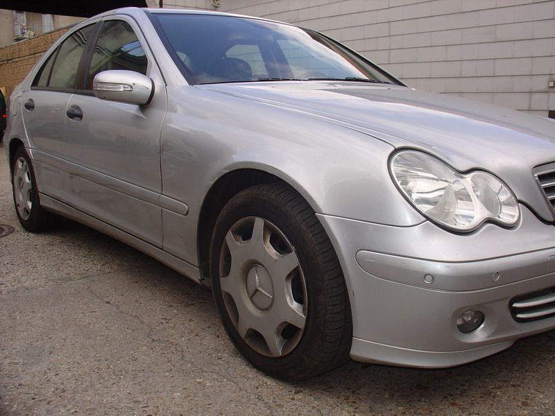 Ein silberner Mercedes steht auf einer Kiesauffahrt