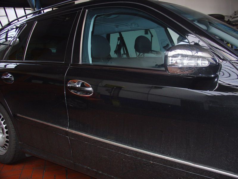 Ein schwarzes Auto mit Chromverzierung steht in einer Garage