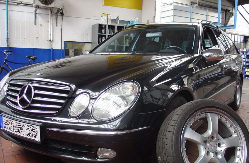 Ein schwarzer Mercedes steht neben einem Reifen