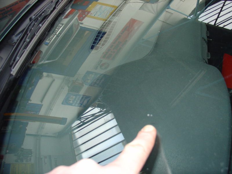 Eine Person, die auf eine Windschutzscheibe eines Autos zeigt, auf der ein Schild mit der Aufschrift „Visa“ steht