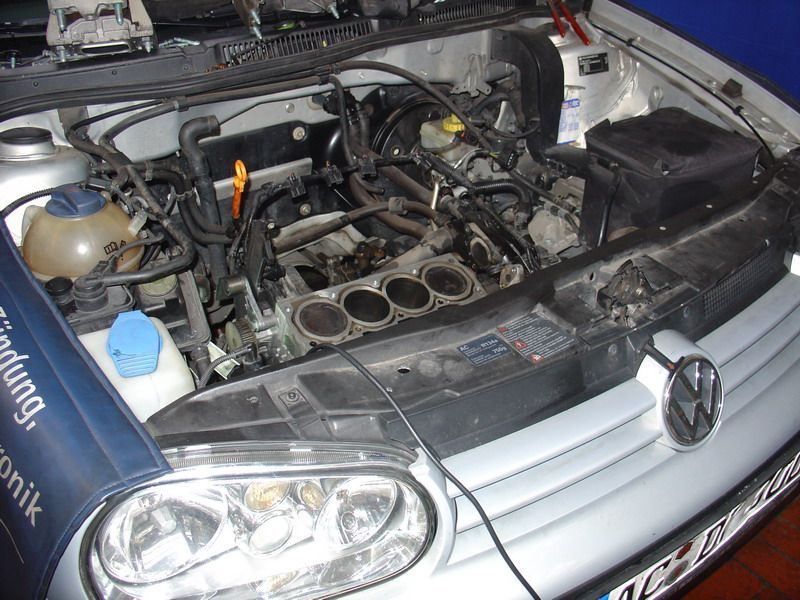 Ein Auto mit offener Motorhaube und einem Schild mit der Aufschrift „Parfümbank“ darauf