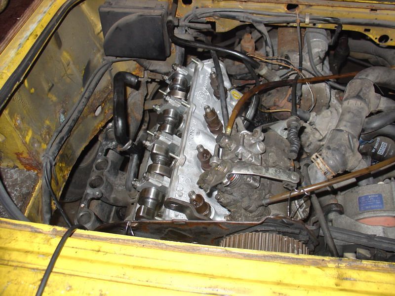 Ein gelbes Auto mit geöffneter Motorhaube und sichtbarem Motor