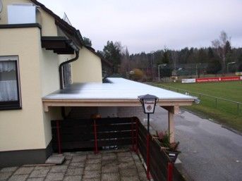 Ein Gebäude mit einem schneebedeckten Carport