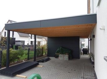 Carport mit Holzdecke, dunkelgrauem Dach und Stützpfosten
