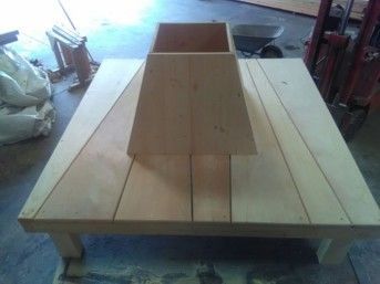 Holztisch mit einem zentralen, erhöhten Gestell.