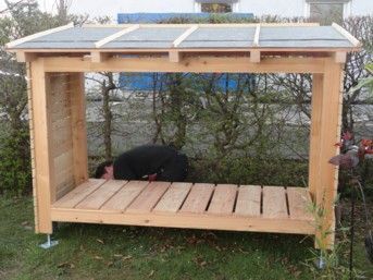 Ein Mann arbeitet in einem hölzernen Schuppen mit schrägem Dach.