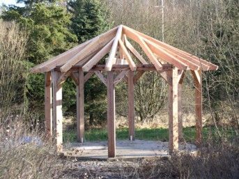 Holzrahmenkonstruktion eines Pavillons in natürlicher Umgebung.