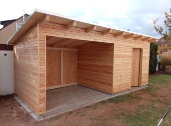 Holzgarage mit Betonboden, auf Rasenfläche. 