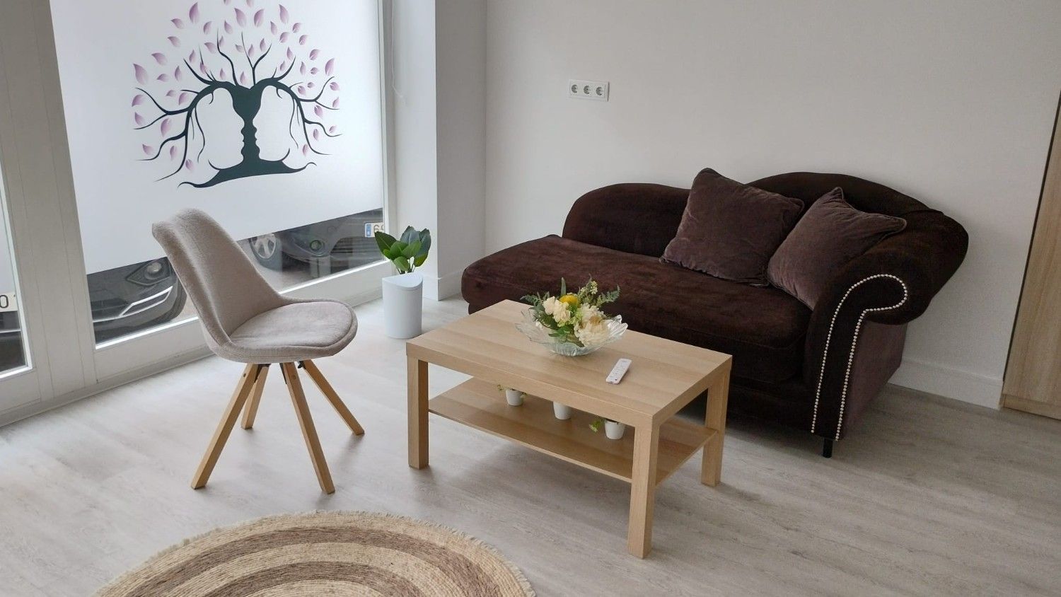 Un consultorio de terapia moderno y minimalista con un sofá marrón