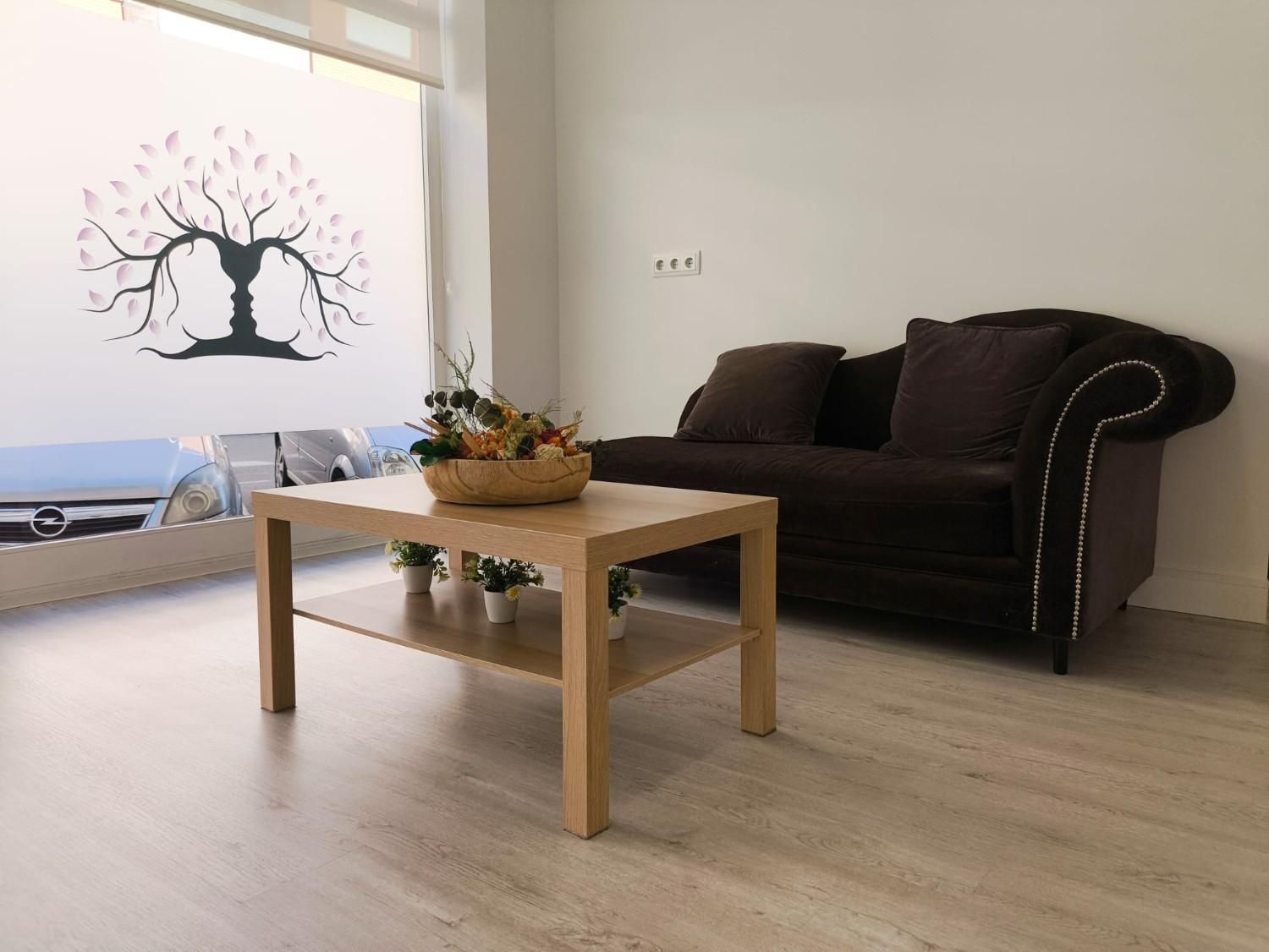 Una sala de espera con un sofá marrón