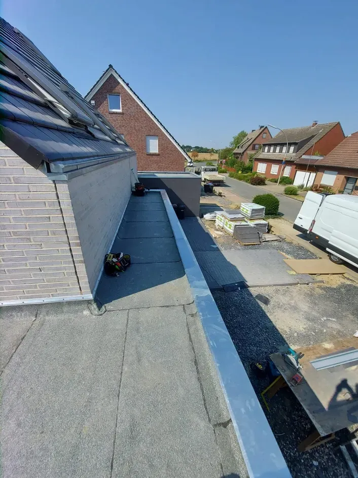 Auf dem Dach eines Hauses wird eine Dachrinne installiert