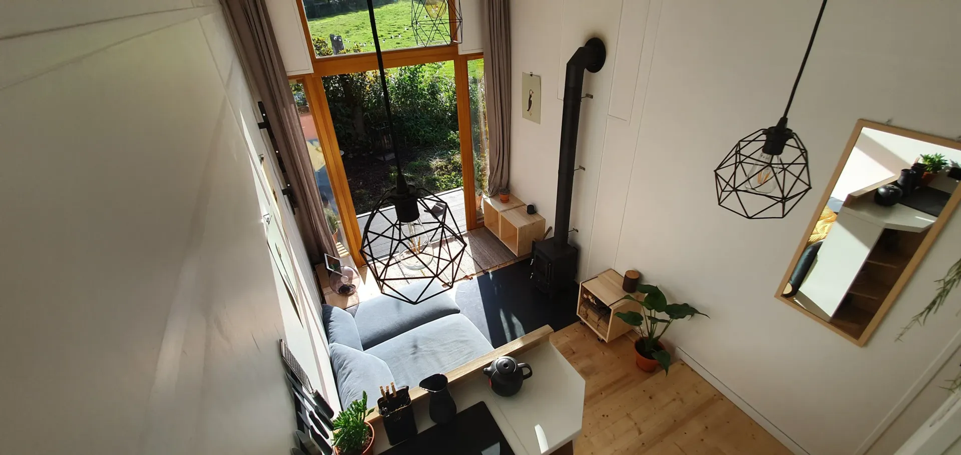 Eine Luftaufnahme eines Wohnzimmers mit Kamin und Spiegel.