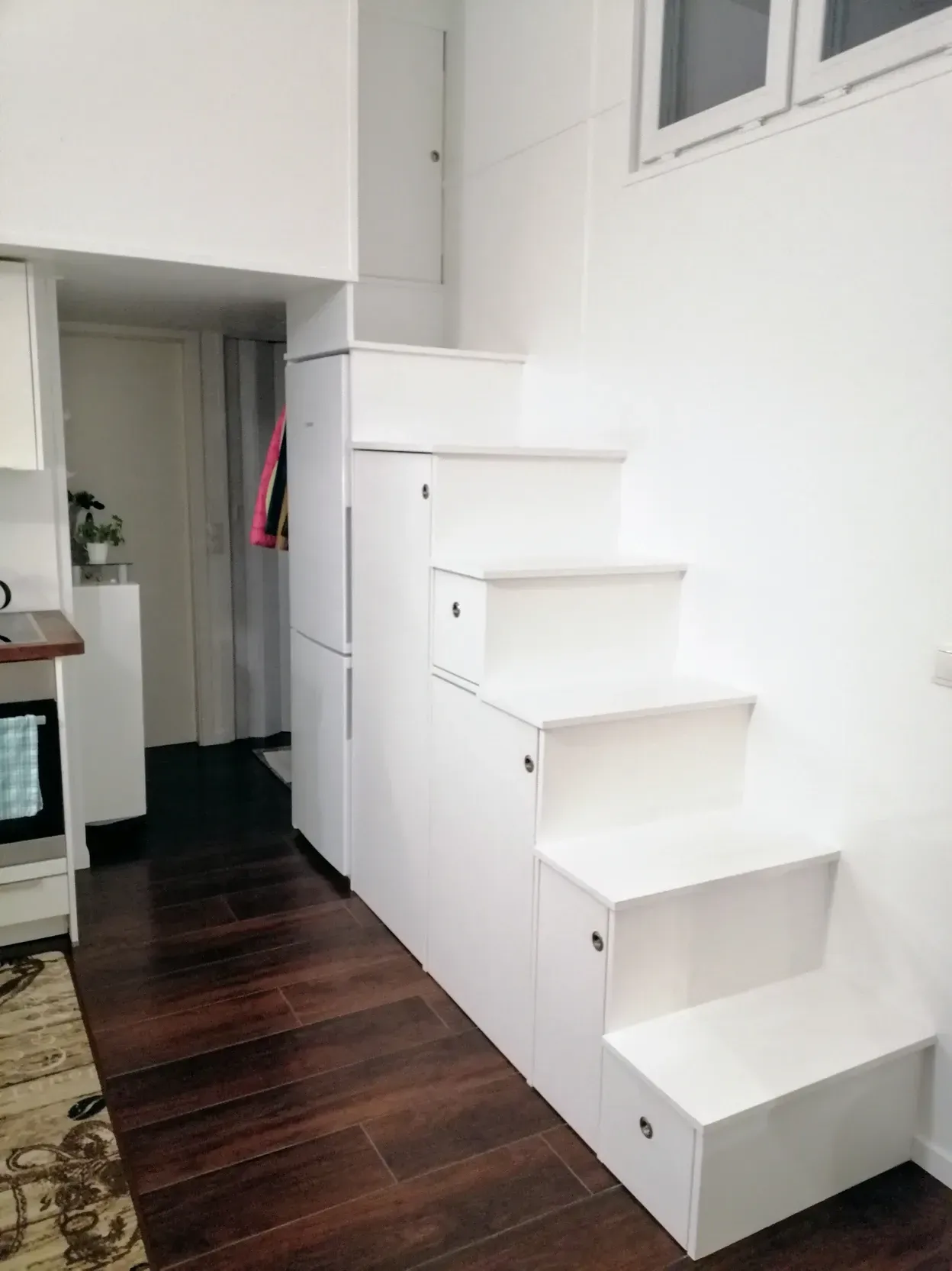 Eine weiße Treppe führt zu einem Loft in einer Küche.