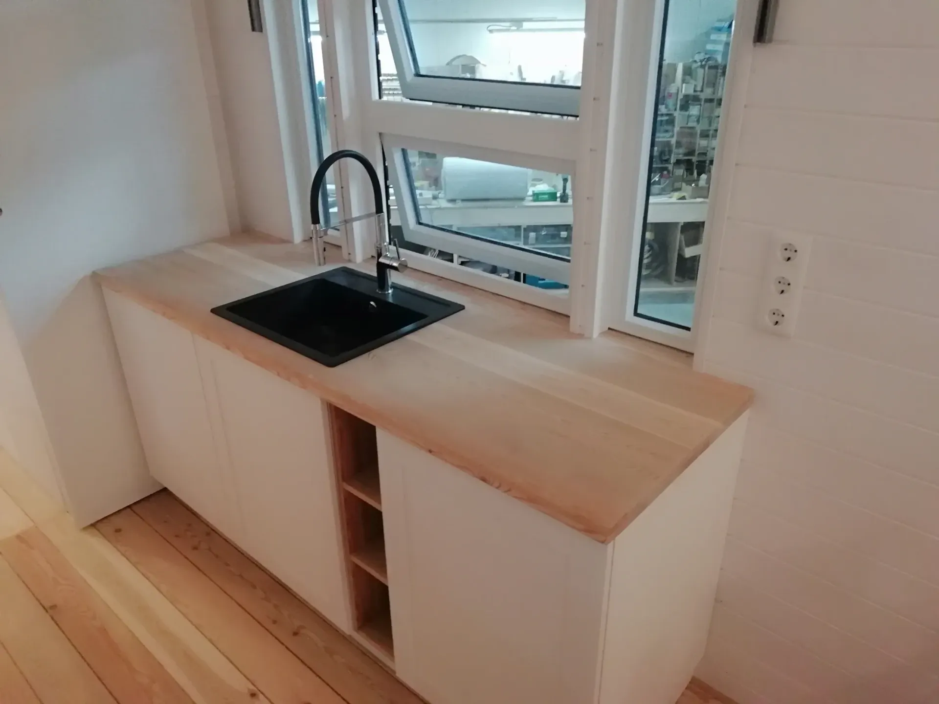 Eine Küchentheke mit Spüle und Fenster