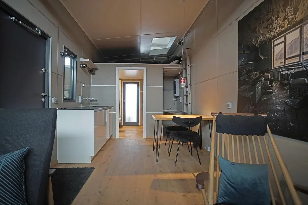 Ein Wohnzimmer mit einem Tisch und Stühlen und einem Gemälde an der Wand.