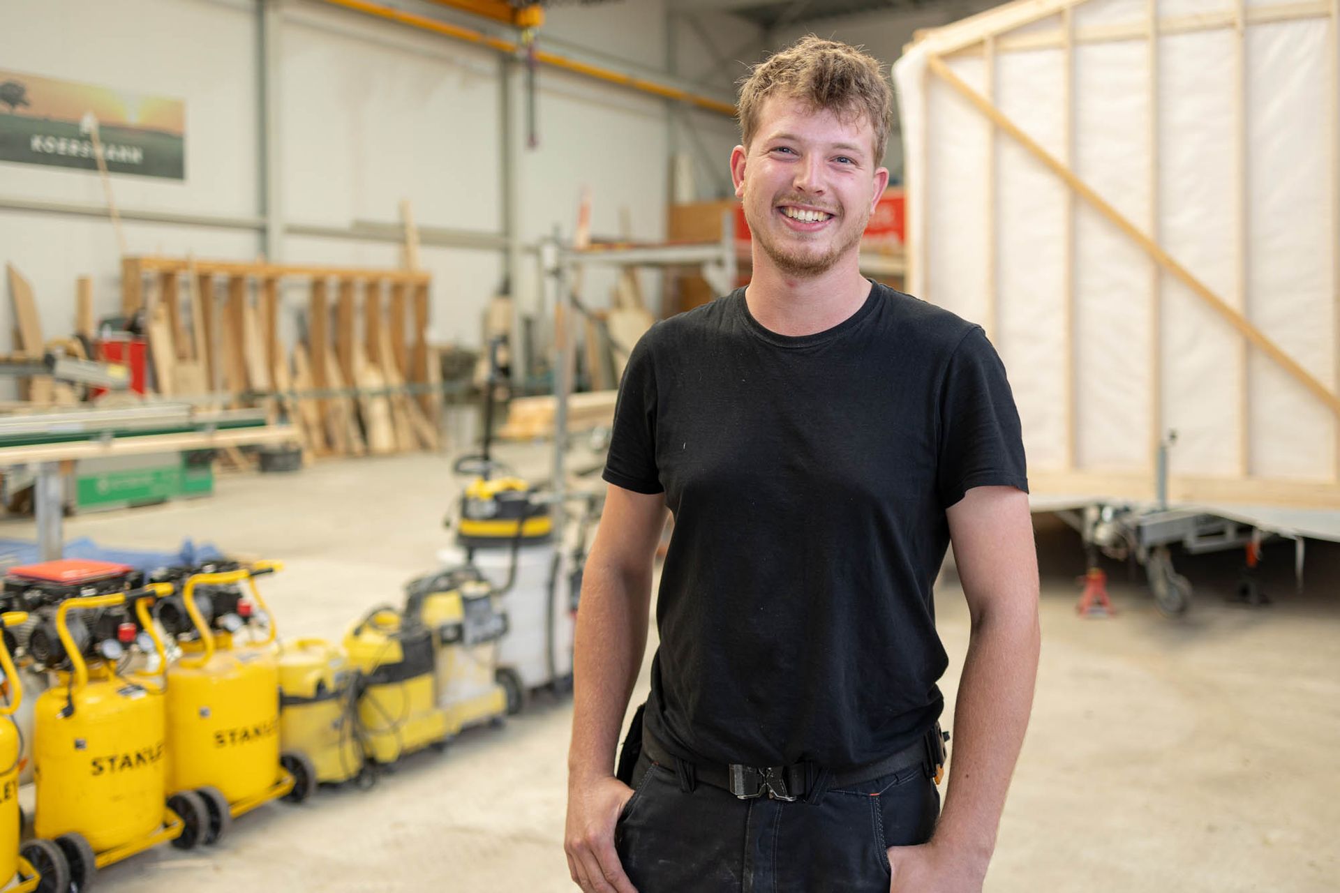 Ein Mann steht mit den Händen in den Taschen in einem Lagerhaus.