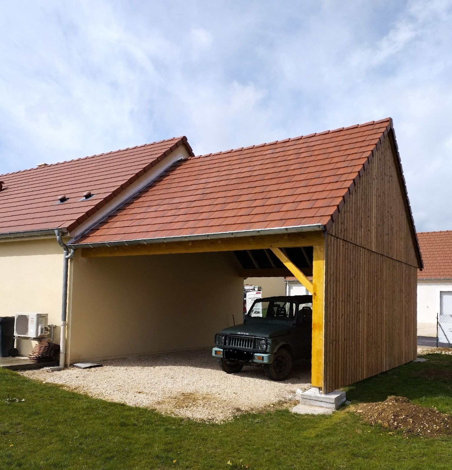 Une maison avec un abris pour les voiture