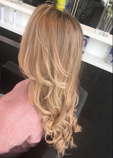 Eine Frau mit langen blonden Haaren sitzt auf einem Stuhl.