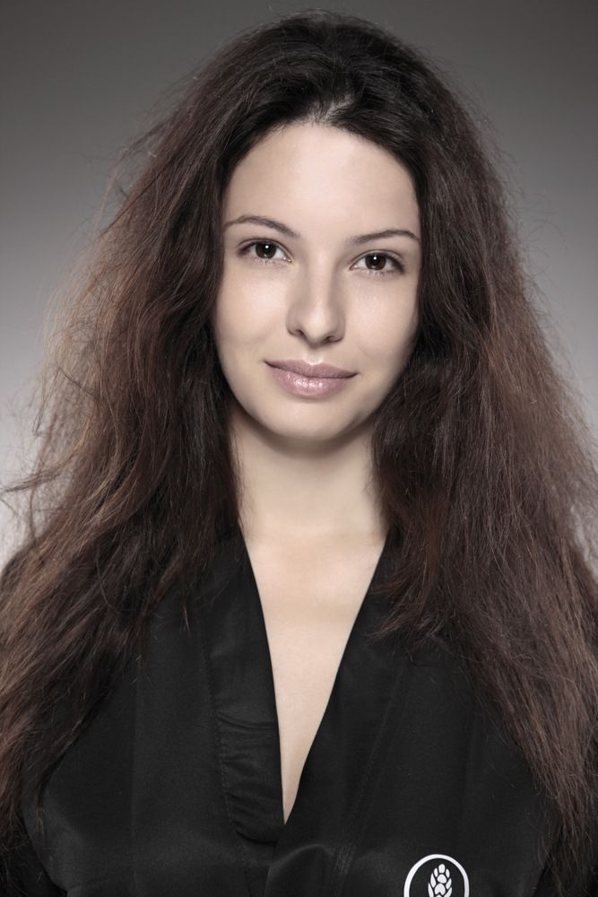 Eine Frau mit langen braunen Haaren trägt eine schwarze Jacke