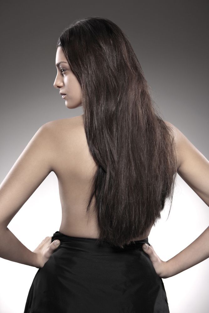 Eine Frau mit langen Haaren steht mit den Händen auf den Hüften.
