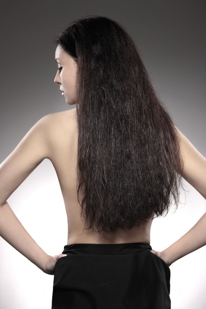 Eine Frau mit langen Haaren steht mit den Händen auf den Hüften